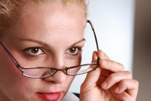 woman taking off glasses